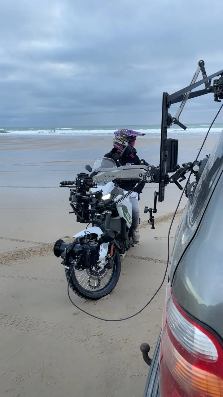 Tournage d'une moto Kawasaki sur la plage, caméra montée sur un bras de voiture travelling